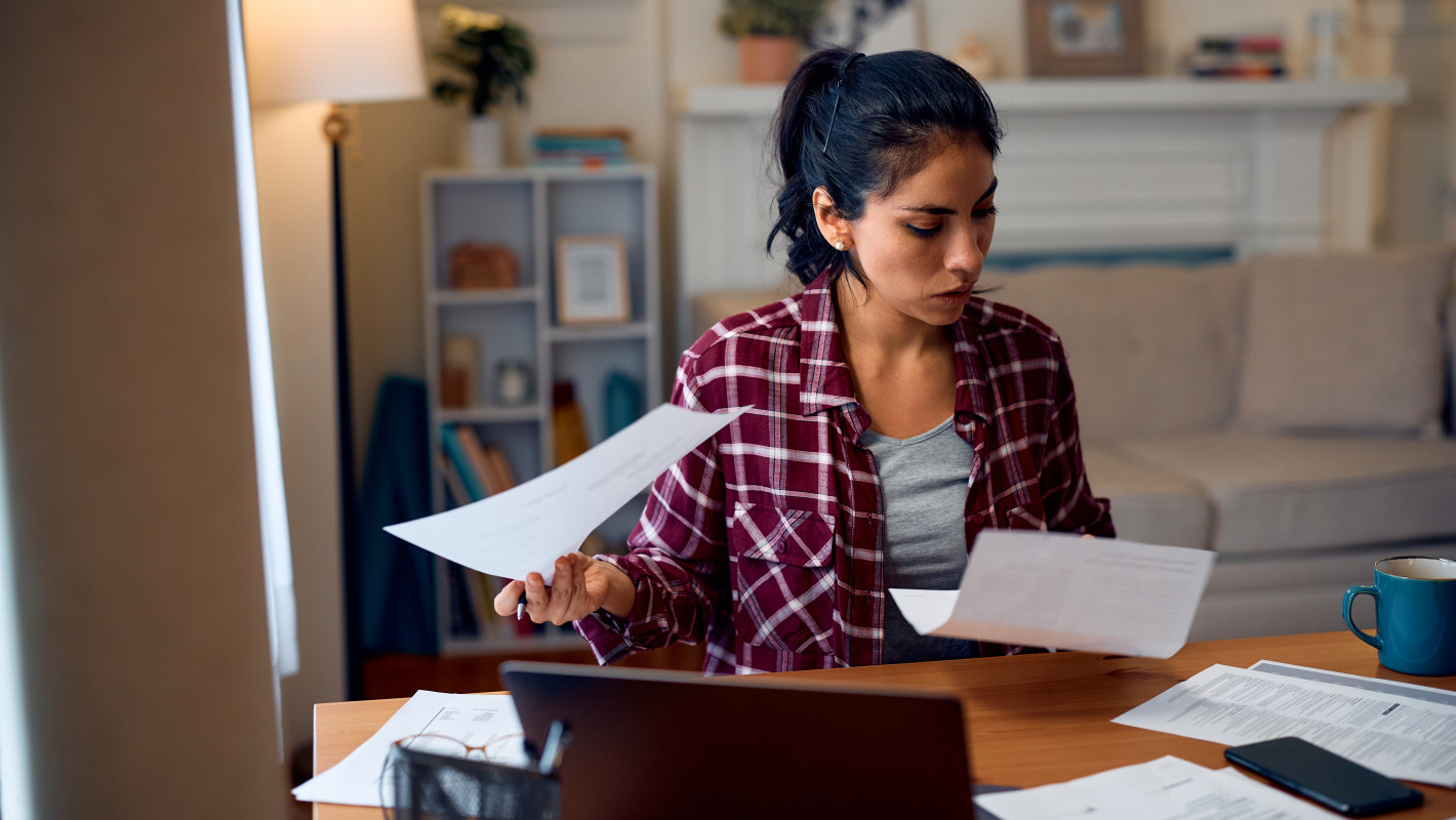 Woman checks her bank statements at home