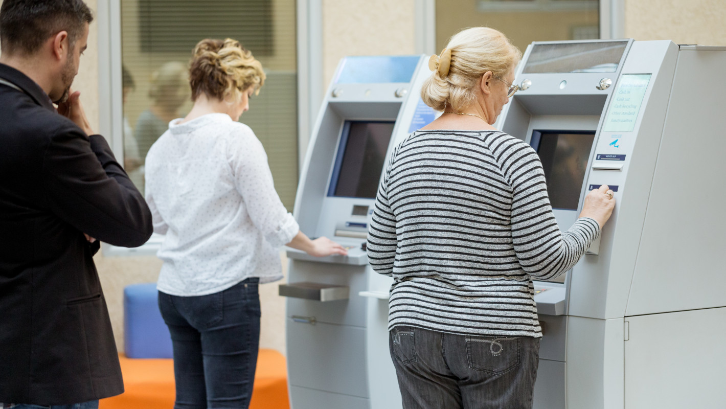 Personen in Bankfiliale heben Geld ab