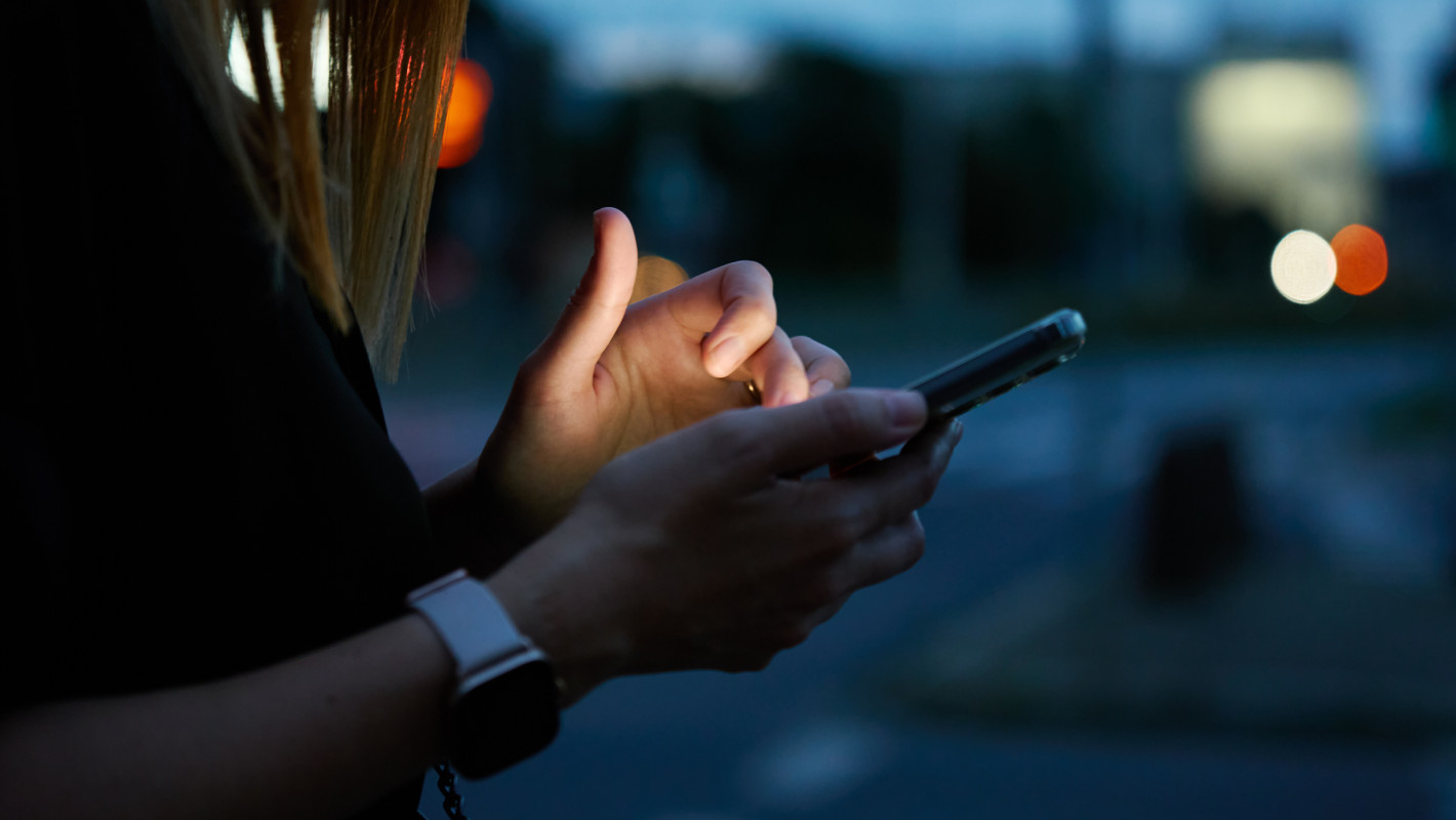 Frau benutzt ihr Smartphone am Abend