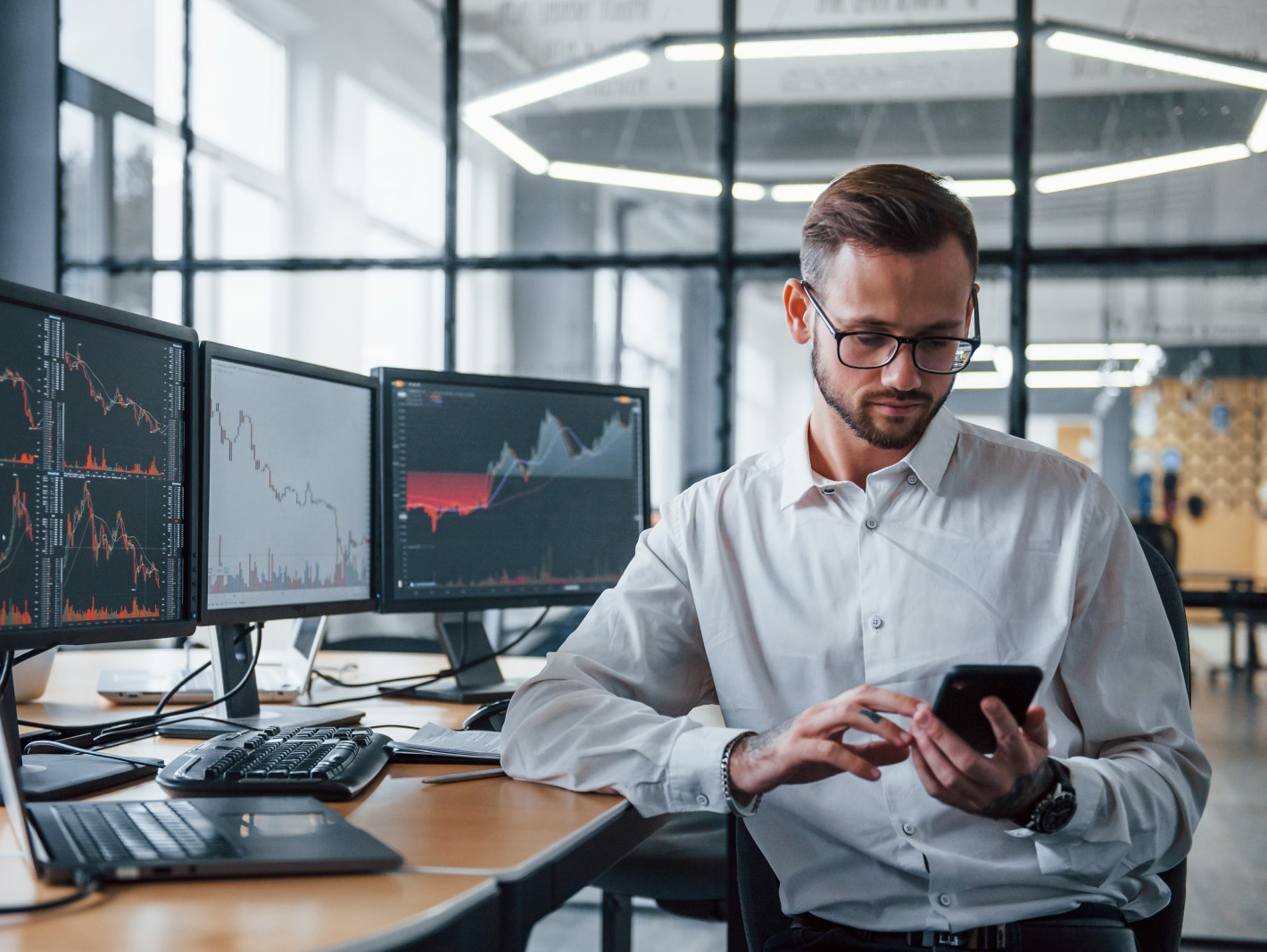 Börsenmakler prüft sein Smartphone