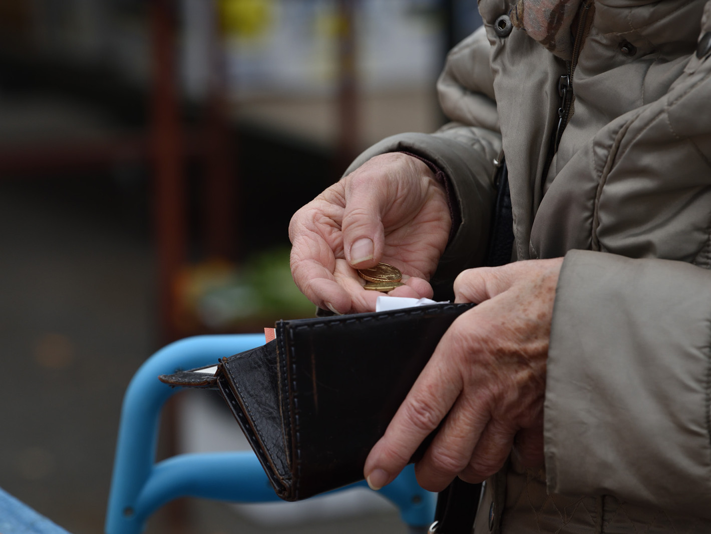 Alter Mann zählt Geld in seinem Portemonnaie